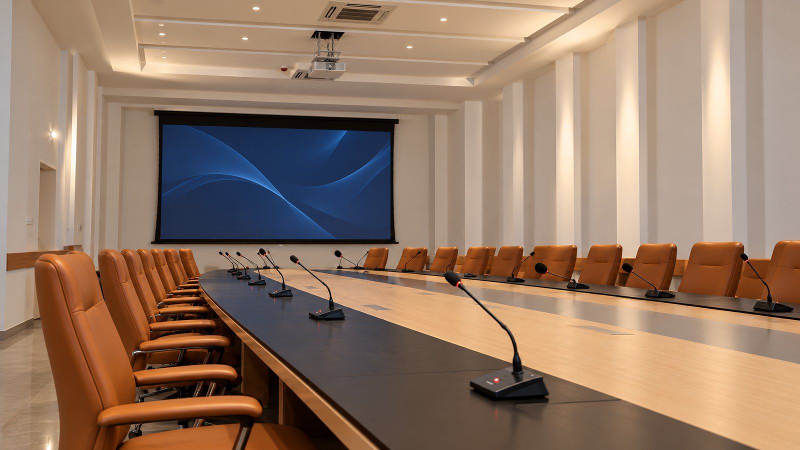 Salle du conseil de l'Agence urbaine de Meknès : grande table équipée de microphones col de cygne, fauteuils fauves, écran de projection et vidéoprojecteur au plafond